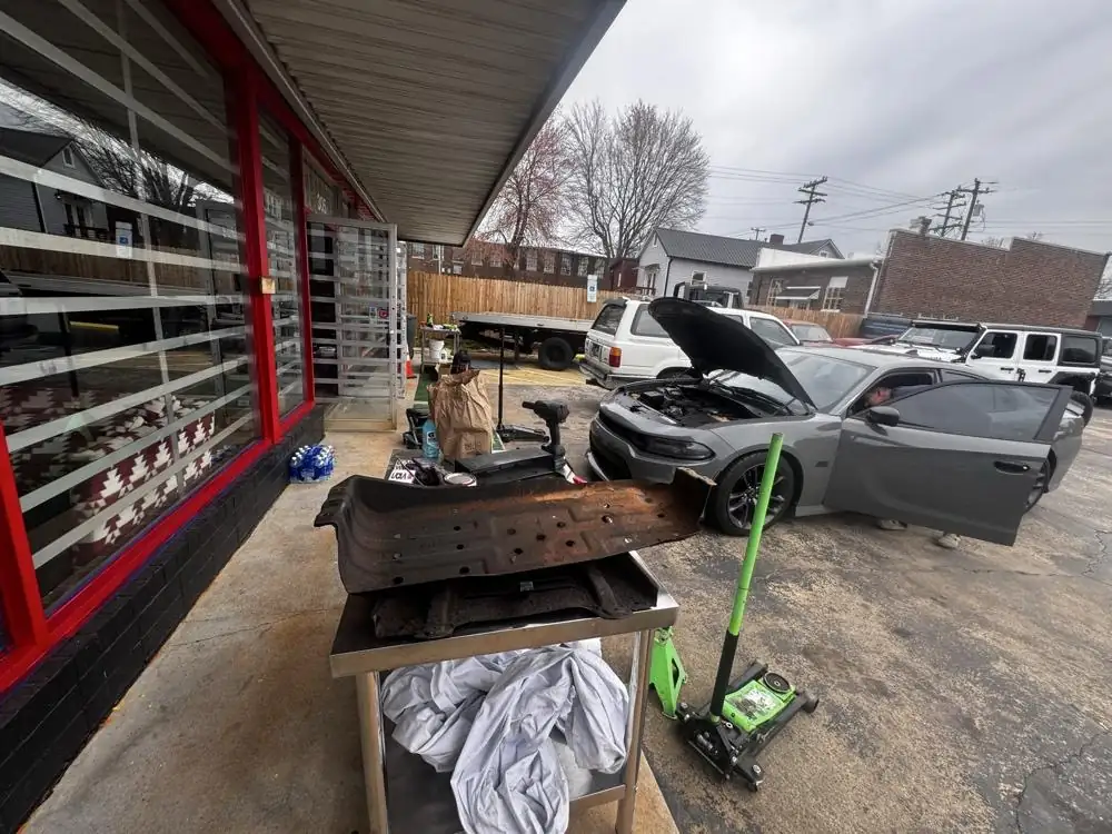Graham Tire Center on West Harden Street with a car up on the jack mid-job
